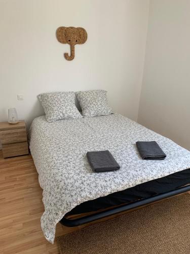 a bedroom with a bed with two towels on it at Hébergement Guer in Guer
