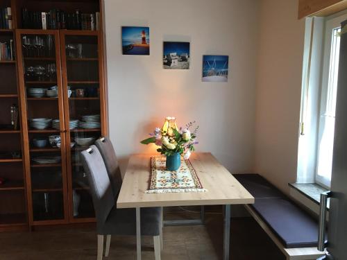 Una mesa de comedor con un jarrón de flores encima. en Ferienwohnung Turmblick, en Marienrachdorf