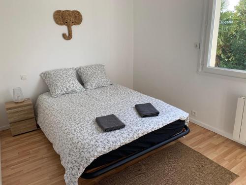 a bedroom with a bed with two towels on it at Hébergement Guer in Guer