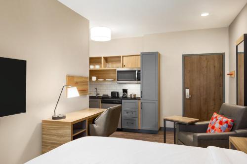 a room with a bed and a desk and a kitchen at Candlewood Suites Shelbyville, an IHG Hotel in Shelbyville