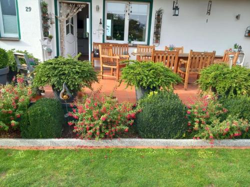 a patio with chairs and flowers in front of a house at direkt am Wasser ""Küstenperle"mit Meerblick und Sauna in Hohenkirchen