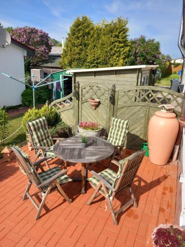 a patio with a table and chairs on a brick patio at direkt am Wasser ""Küstenperle"mit Meerblick und Sauna in Hohenkirchen
