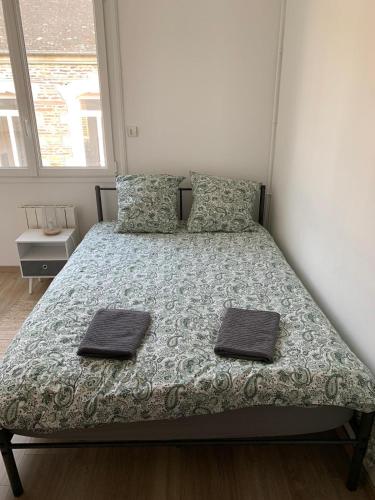 a bedroom with a bed with two towels on it at Hébergement Guer in Guer