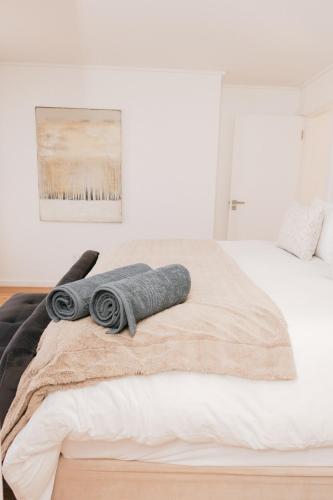 a bed with a towel on top of it at Thyme & Tide Beach Villa in Yzerfontein