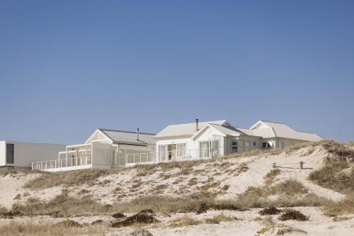 a row of houses on top of a beach at Thyme & Tide Beach Villa in Yzerfontein