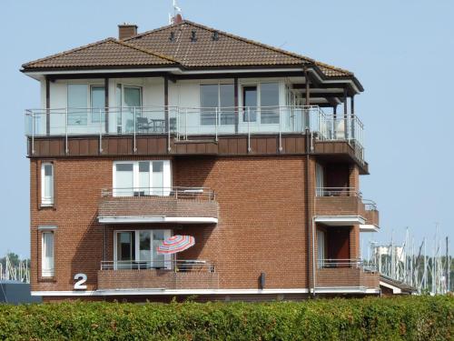 - un bâtiment en briques rouges avec un balcon et un drapeau américain dans l'établissement ancora Marina Haus 2 Nr 02, Typ 2, à Neustadt in Holstein