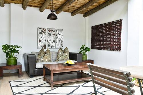 a living room with a couch and a table at Woodall Country House and Spa in Addo