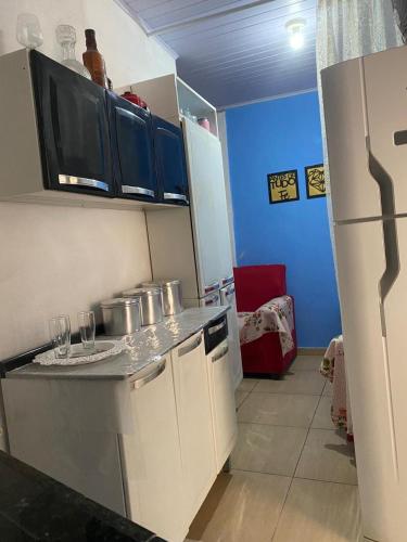 - une cuisine avec un comptoir avec des verres et un réfrigérateur dans l'établissement Kitnet Diamantina, à Diamantina