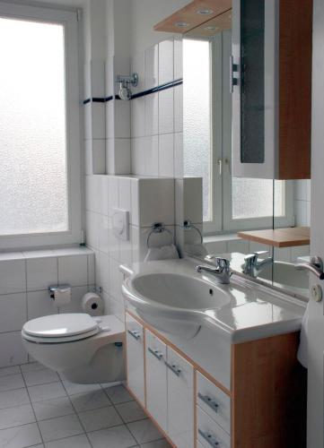 a bathroom with a sink and a toilet and a mirror at Klein aber fein zentrale Ferienwohnung 30qm im Hotel zur Börse in Hameln