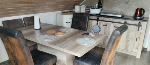 a wooden table with four chairs and a counter at ruhiger als im Hotel, keine andere Gäste in Merkendorf