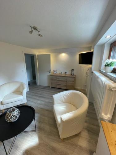a living room with two white chairs and a couch at nordnest in Karlshagen