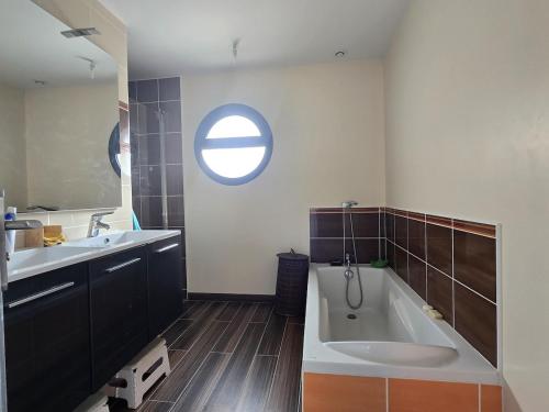 a bathroom with a tub and a sink and a window at la belle de volnay in Volnay