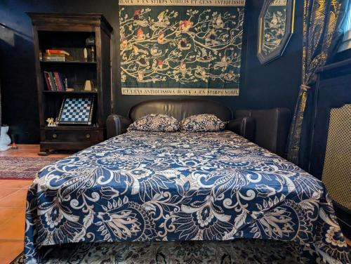 キュエールにあるLa maison sur demandeのベッドルーム1室(青と白の掛け布団付きのベッド1台付)