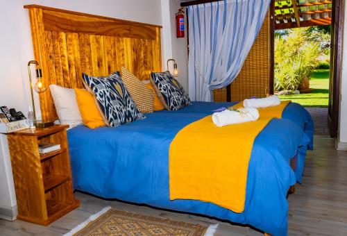 a bedroom with a bed with a blue and yellow blanket at A Cherry Lane Self Catering and B&B in Bloemfontein