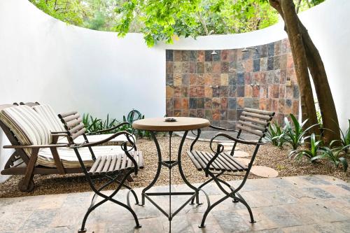 two chairs and a table and chairs on a patio at Woodall Country House and Spa in Addo