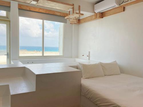 a bedroom with a bed and a large window at White&Light B&B in Manzhou