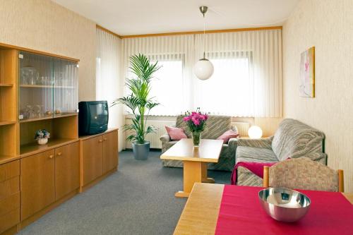 a living room with a couch and a tv at Bartelshof Appartementhaus in Bad Soden-Salmünster