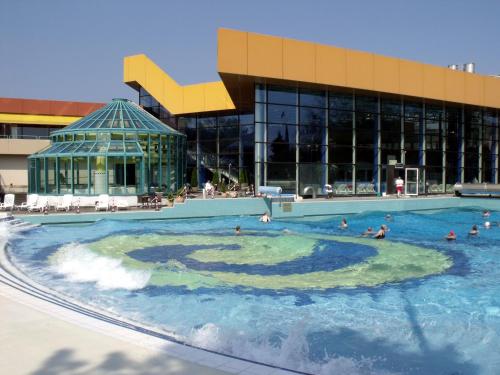 a pool in front of a building with people in it at Bartelshof Appartementhaus in Bad Soden-Salmünster