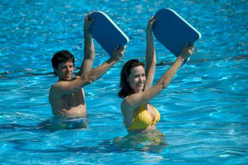 a man and woman in the water holding up paddle boards at Bartelshof Appartementhaus in Bad Soden-Salmünster