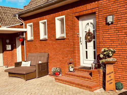 a brick house with a chair and a door at Ferienwohnung mit Seeblick in Jemgum