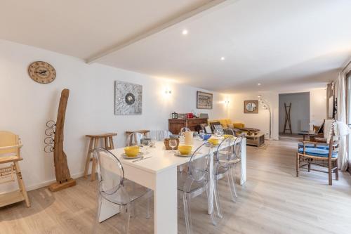 une salle à manger avec une table et des chaises blanches dans l'établissement Maison de Léa - Terrasse - Cœur de Villerville, à Villerville