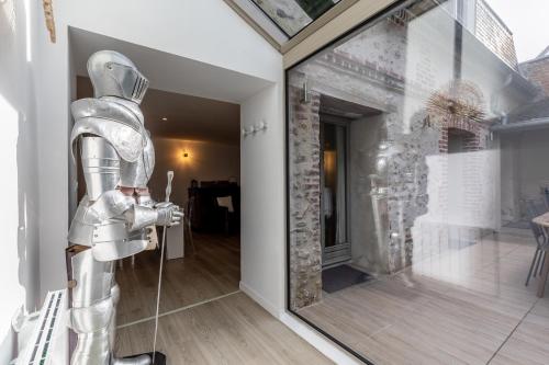 une chambre avec un robot debout à côté d'une porte en verre dans l'établissement Maison de Léa - Terrasse - Cœur de Villerville, à Villerville