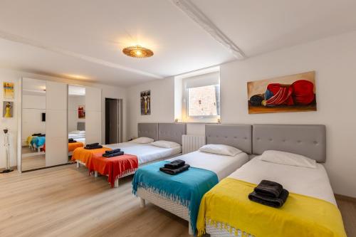 - une chambre avec 3 lits et un miroir dans l'établissement Maison de Léa - Terrasse - Cœur de Villerville, à Villerville