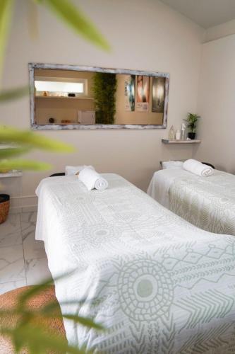 two beds in a room with a mirror at Eva Spa Resort Rooftop Pool 1br By Lucha in Savaneta