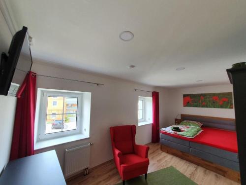 a bedroom with a red bed and a red chair at Landhaus Oberlausitz in Malschwitz