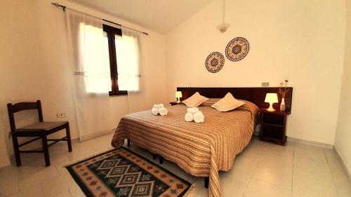 una camera da letto con un letto con due asciugamani sopra di Ferienhaus Casa Limone - Villaggio Galanu a Costa Paradiso