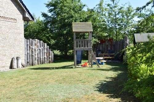 a wooden chair sitting in the middle of a yard at "Leuchtturm" in Fuhlendorf