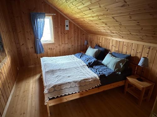 a bedroom with a bed in a wooden cabin at Stort hus på Fen i Ulefoss i rolige omgivelser in Ulefoss