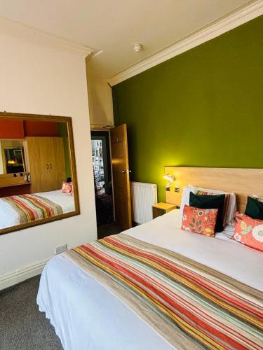 a hotel room with two beds and a mirror at The Beaucliffe Hotel in Blackpool