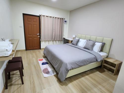 a bedroom with a large bed and a desk and a table at 78's Hometel Pattaya 103 in Pattaya Central