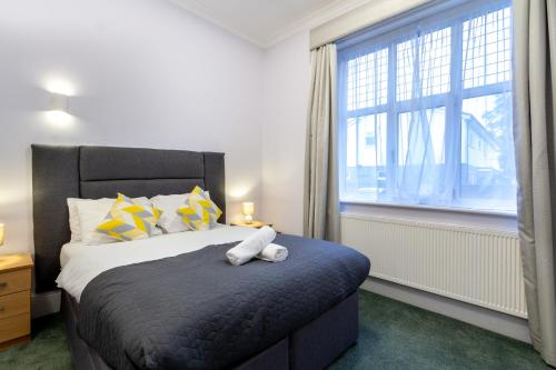 a bedroom with a bed and a large window at London Gatwick Inn in London