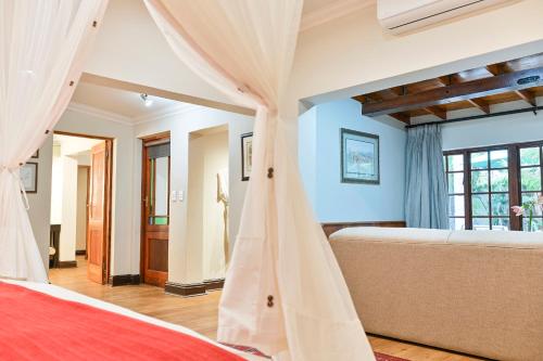 a bedroom with a bed with curtains in it at Woodall Country House and Spa in Addo