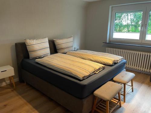a bed in a room with two chairs and a window at Ferienhaus Osterende in Bordelum