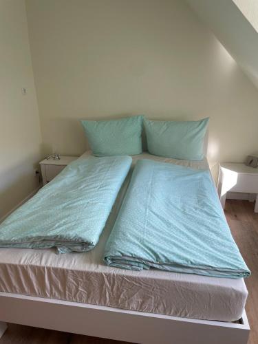 a bed with two blue pillows on top of it at Ferienhaus Osterende in Bordelum