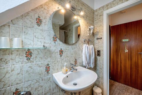 a bathroom with a sink and a mirror at Ferienwohnungen Kastenmüller in Westerdeichstrich