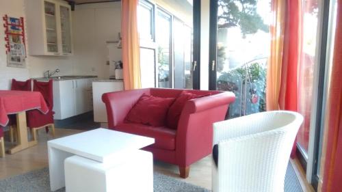 a living room with a red chair and a table at Ferienhaus Börstel mit Klimaanlage, Löhne in Löhne