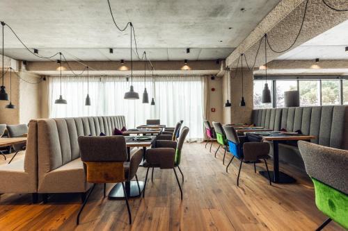 a restaurant with rows of tables and chairs at Loom in Bolzano