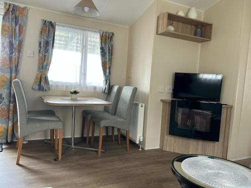 TV a/nebo společenská místnost v ubytování Chalet Kegelrobbe mir riesiger überdachter Terrasse am Kransburger See 544