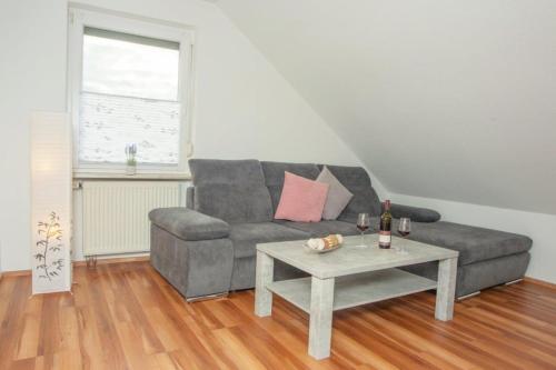 a living room with a grey couch and a table at Ferienwohnung Grauschiefer in Irsch