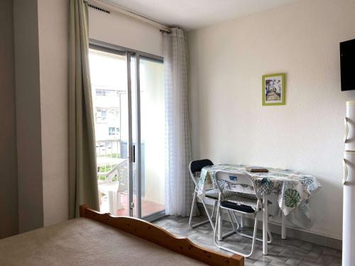 Cette chambre dispose d'une table, de chaises et d'un balcon. dans l'établissement Studio Confortable avec Balcon et Wifi près du parc Charles de Gaulle à Balaruc-les-Bains - FR-1-553-37, à Balaruc-les-Bains