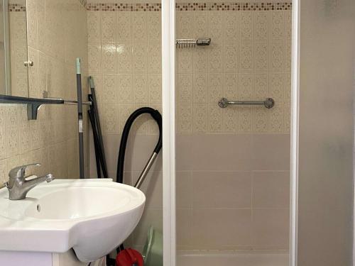 La salle de bains est pourvue d'un lavabo et d'une porte de douche en verre. dans l'établissement Studio Confortable avec Balcon et Wifi près du parc Charles de Gaulle à Balaruc-les-Bains - FR-1-553-37, à Balaruc-les-Bains