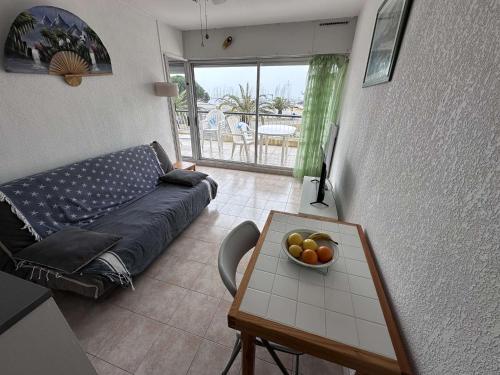 un salon avec un canapé et une table avec un bol de fruits dans l'établissement Appartement cosy 4 pers avec parking à Port Camargue - FR-1-731-103, au Grau-du-Roi