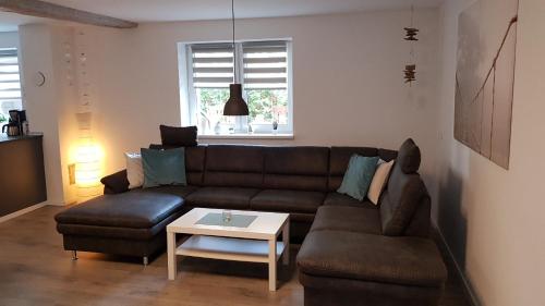 a living room with a brown couch and a table at Ferienhaus Loreleytraum, Wohnung Erdgeschoss in Sankt Goarshausen