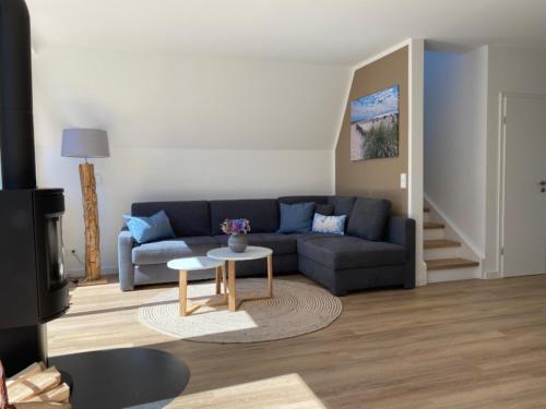 a living room with a blue couch and a table at Heimathafen Damp, Haus 9 in Damp