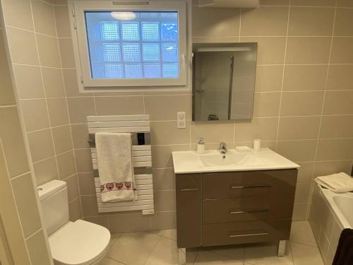 une salle de bain avec un lavabo et des toilettes et une fenêtre dans l'établissement Appart 4 ou 5 pers - Bike Friendly, au Bourg-dʼOisans