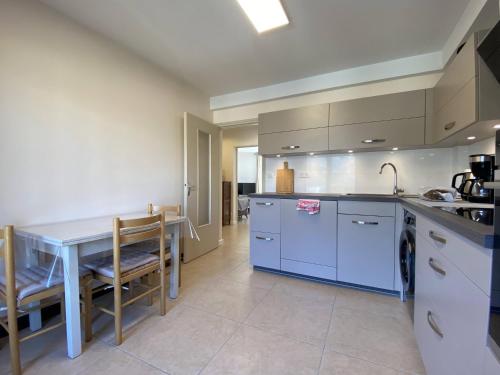 une cuisine avec des placards bleus et une table avec un évier dans l'établissement Appart 4 ou 5 pers - Bike Friendly, au Bourg-dʼOisans